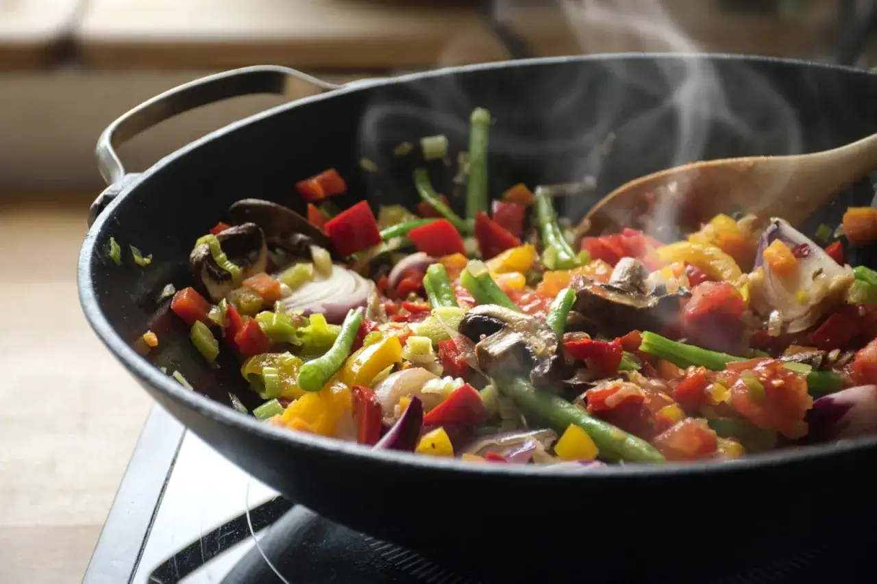 Légumes colorés sautés dans une poêle, cuits avec de l'huile d'olive. Une cuisson saine, sans se soucier du cholestérol.