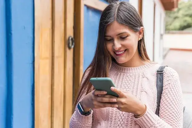 Dziewczyna pisząca wiadomość na smartfonie, uśmiechnięta