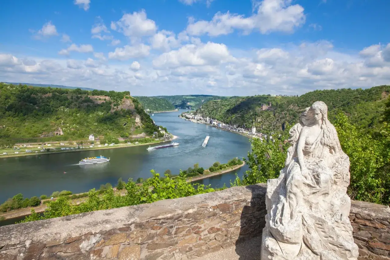 Ein Blick auf den Rhein mit Schiffen und Burgen, ein versteckter Ort mit einer Statue, der zu den Geheimtipps am Rhein gehört.