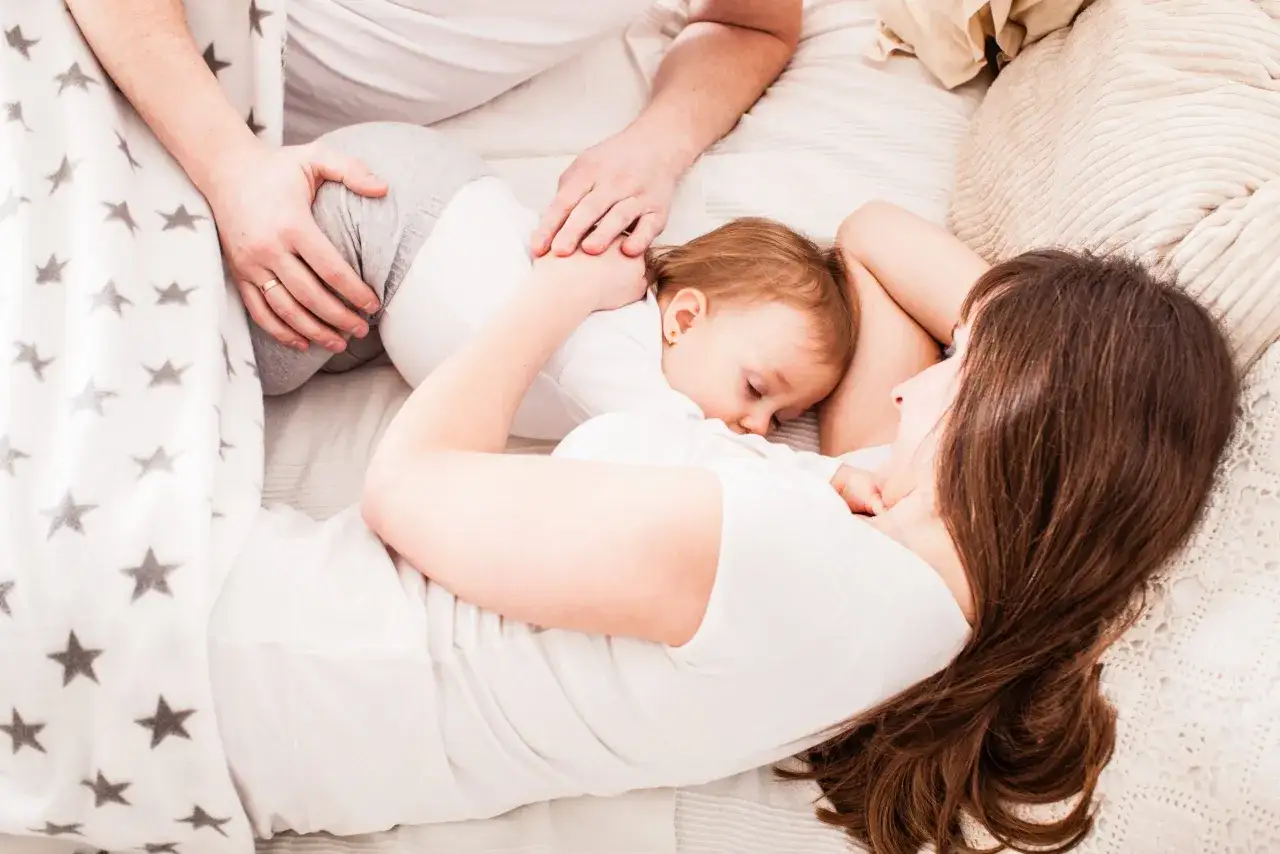 Un tenero momento a letto con i miei figli. La mamma abbraccia il suo piccolo, mentre il pap&agrave; veglia su di loro.