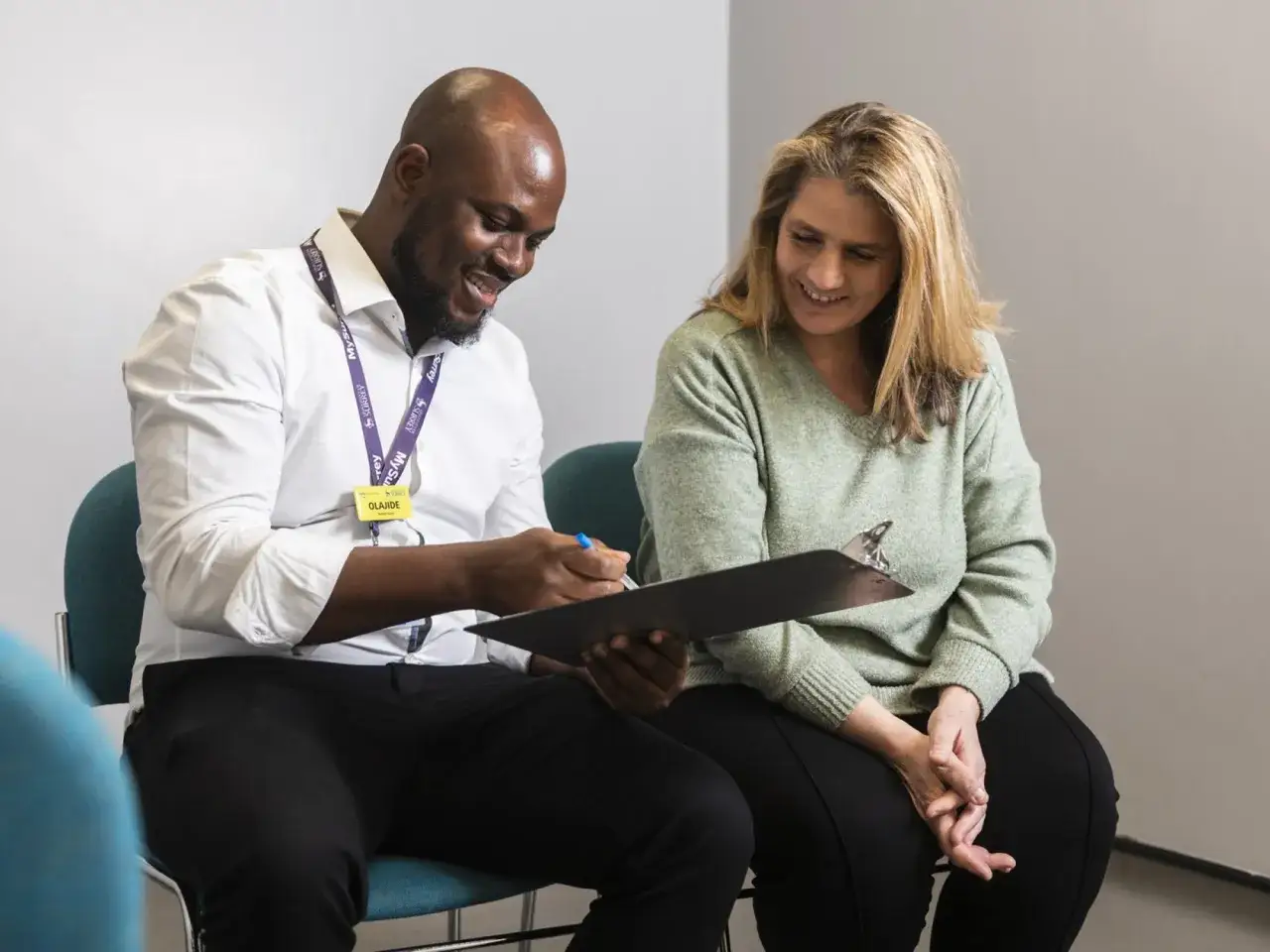 A healthcare professional smiles while reviewing notes with a patient, highlighting the supportive nature of mpa healthcare.