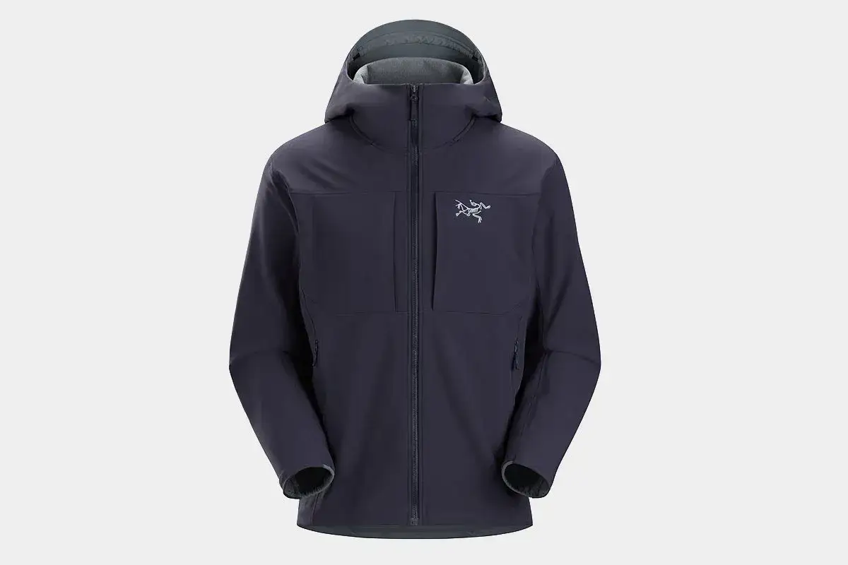 Granatowa kurtka softshell z kapturem i logo. Idealna na zmienną pogodę, chroni przed wiatrem i deszczem.