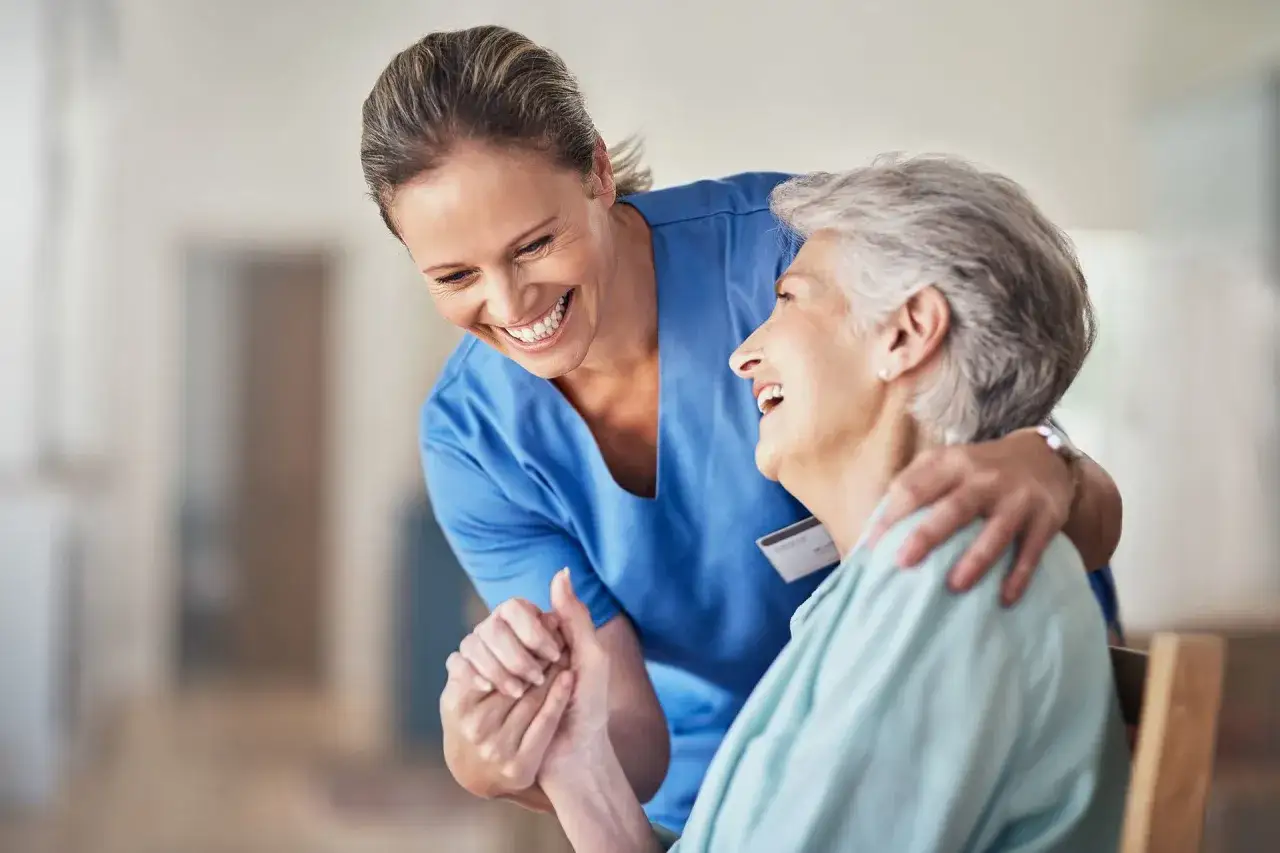 Un sorriso e una mano che stringe l'altra: un abbraccio che mostra il **socio sanitario che lavoro puoi fare**, offrendo cura e compagnia.