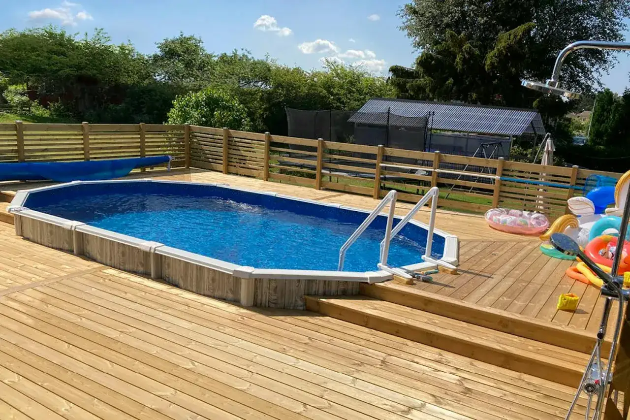 En härlig sommardag med en nybyggd pool. Trädäcket runt poolen är perfekt för att bygga in en rund pool.