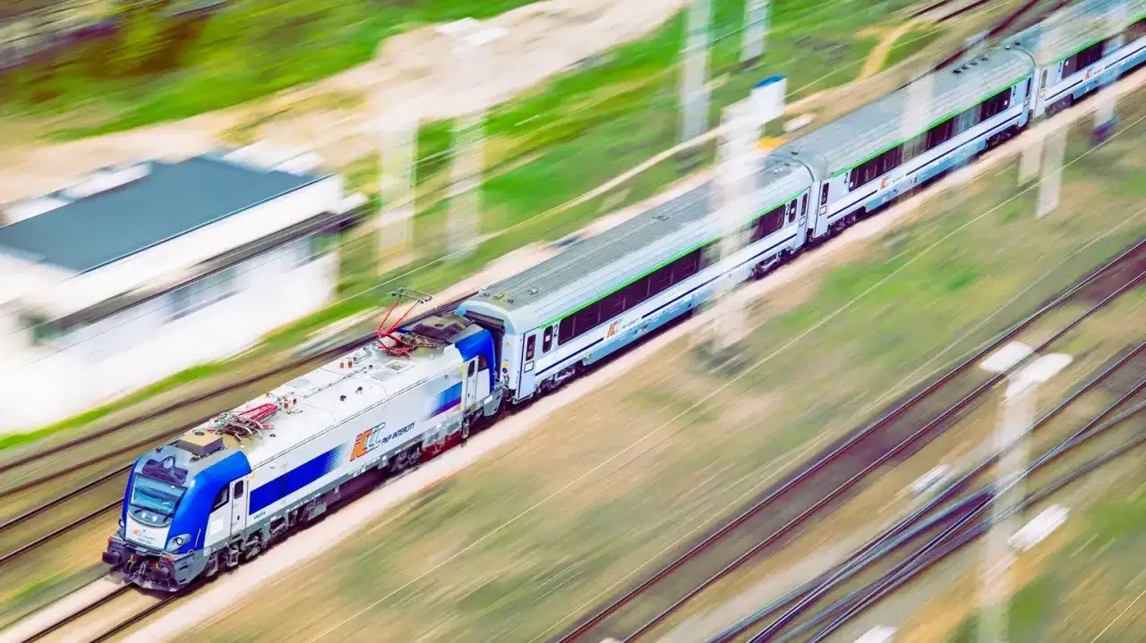 Pociąg PKP Intercity pędzi po torach, łącząc Lublin z Kołobrzegiem.