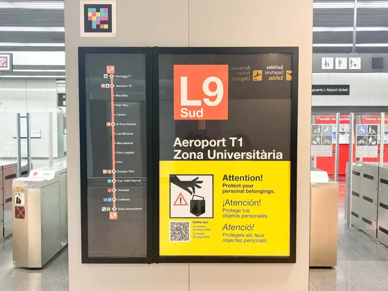 Tablica informacyjna na **barcelona lotnisko** pokazuje trasę metra L9 Sud do Aeroportu T1 i innych stacji. Ostrzeżenie przypomina o pilnowaniu rzeczy.
