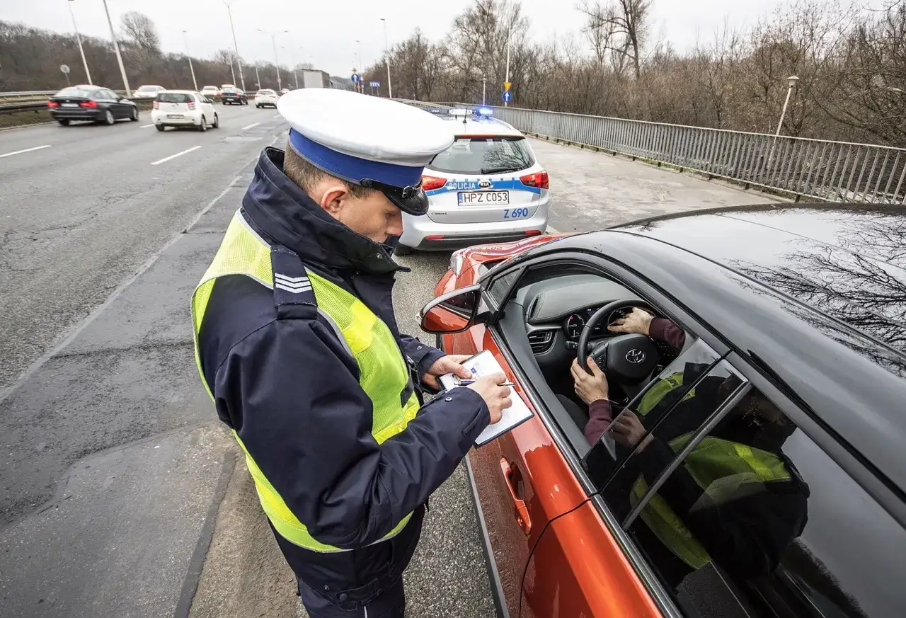 Policjant spisuje mandat. Kierowca może się bronić, znając art. 97 k.w.