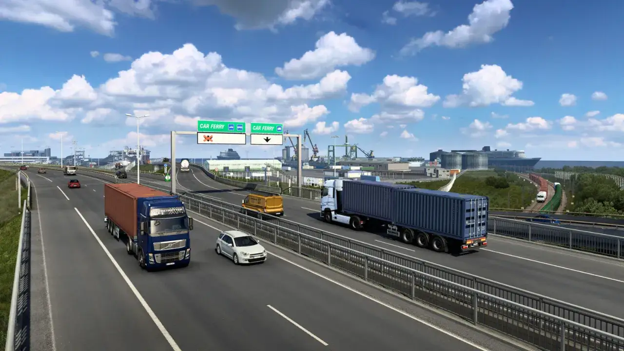 Droga do portu w Euro Truck Simulator 2 na PS5. Ciężarówki i samochody jadą autostradą w kierunku promu.
