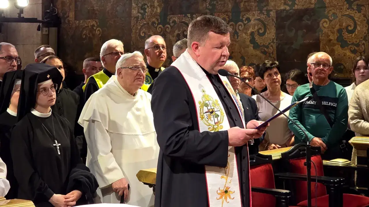 Ksiądz czyta z mszału, omawiając przyczyny zmian w tekstach modlitw w nowym mszale rzymskim. Wokół zgromadzeni wierni i duchowni.