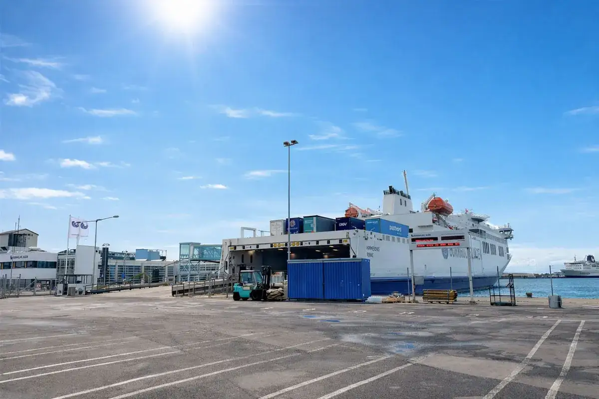 Prom na trasie Świnoujście-Bornholm gotowy do odpłynięcia. W tle widać inne statki i portową infrastrukturę.