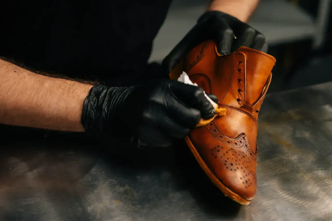 Application de white spirit sur cuir pour nettoyer une chaussure richelieu marron.