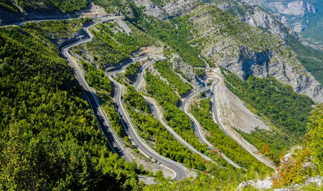 Spektakularne albania widoki: serpentyny wiją się po stromych, zielonych zboczach gór.