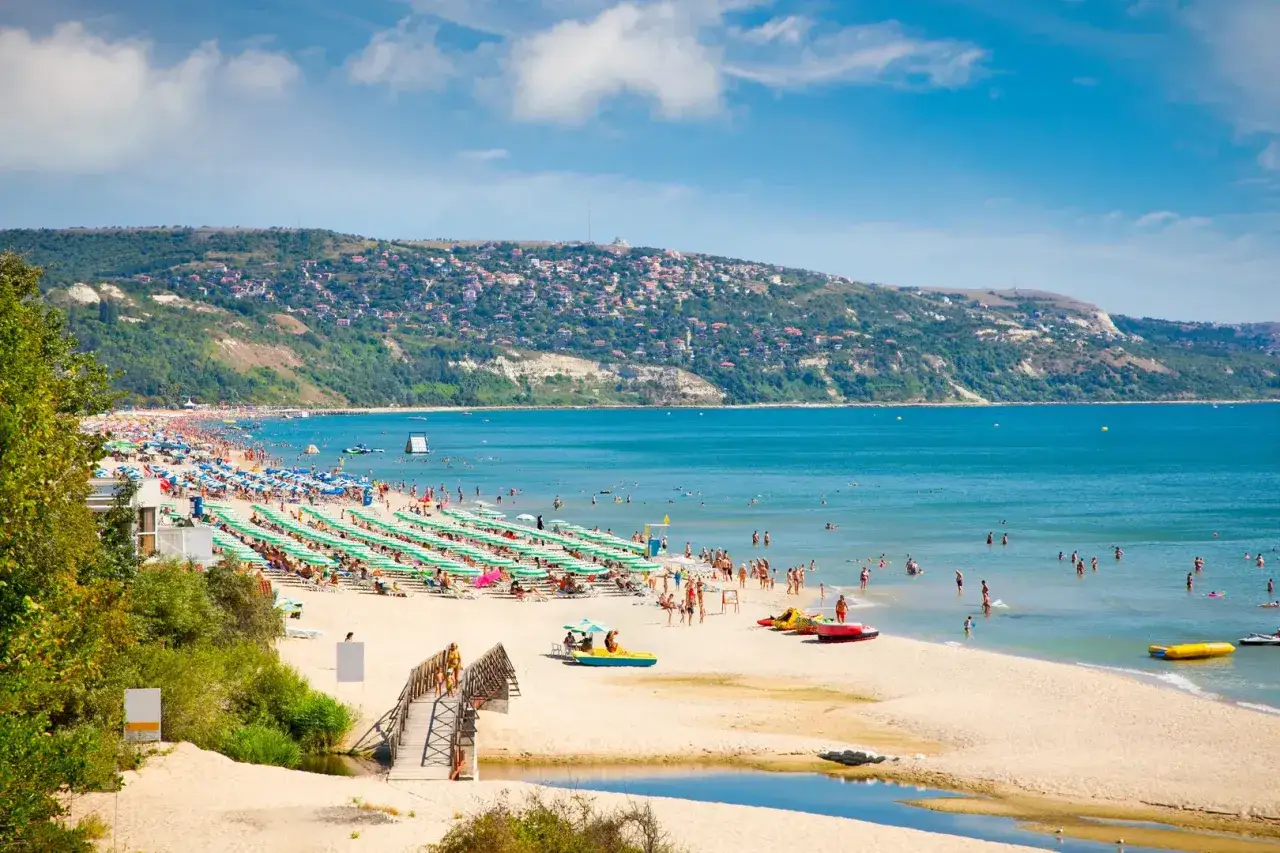 Tłumy ludzi na plaży w Bułgarii, woda czysta, słońce świeci. Czy w Bułgarii jest bezpiecznie? Wygląda na to, że tak, plażowicze cieszą się wakacjami.