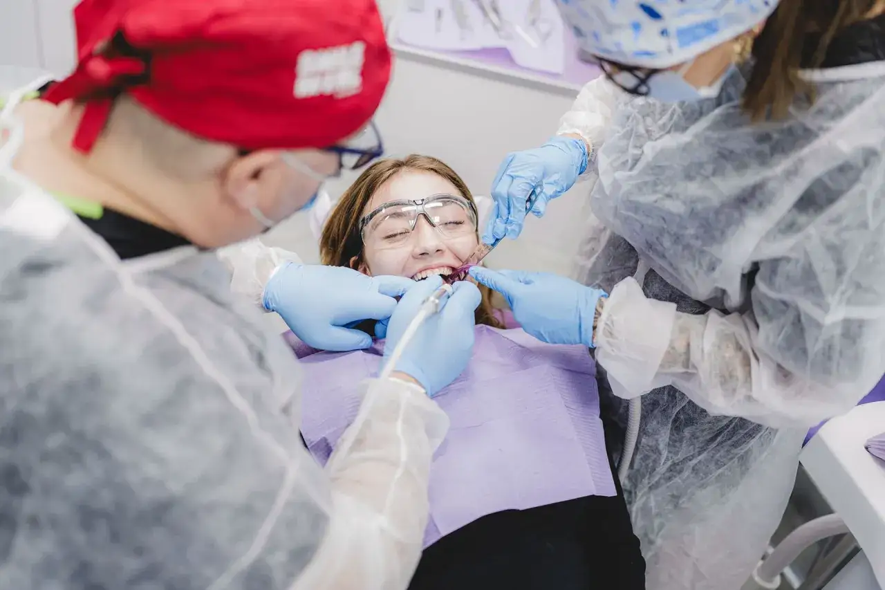 Pacjentka u dentysty, który bada jej zęby. Czy paradontoza jest uleczalna? Zespół medyczny pracuje nad zdrowiem jamy ustnej.