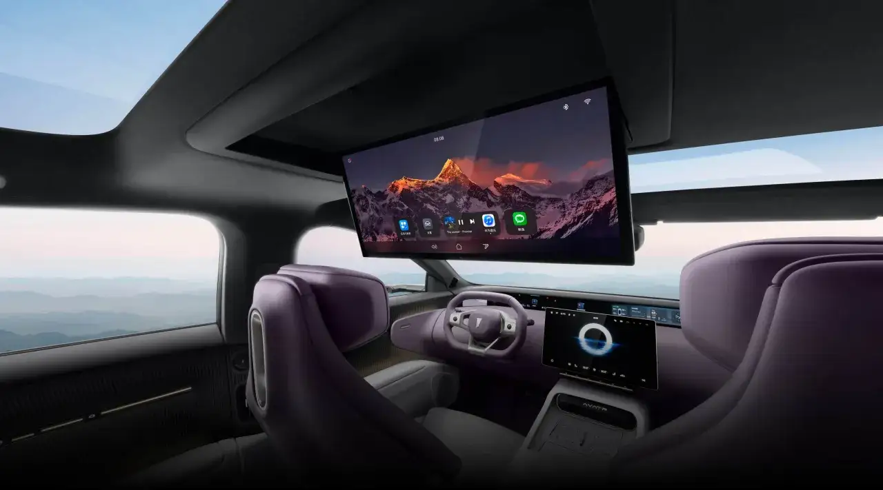 Interior de un coche futurista con asientos morados y una gran pantalla central. El **Avatr 12** ofrece una experiencia de entretenimiento inmersiva.