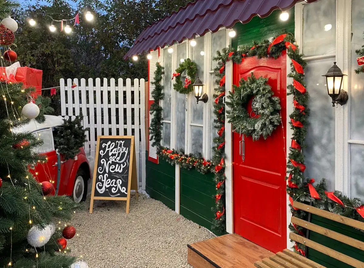 Un angolo incantato con albero di Natale, lucine e una lavagna che annuncia