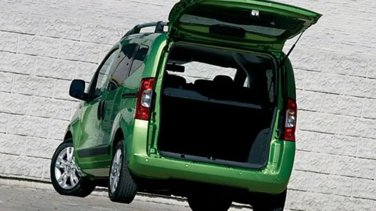 Un Fiat Qubo 2026 verde brillante con il portellone posteriore aperto, pronto per caricare.