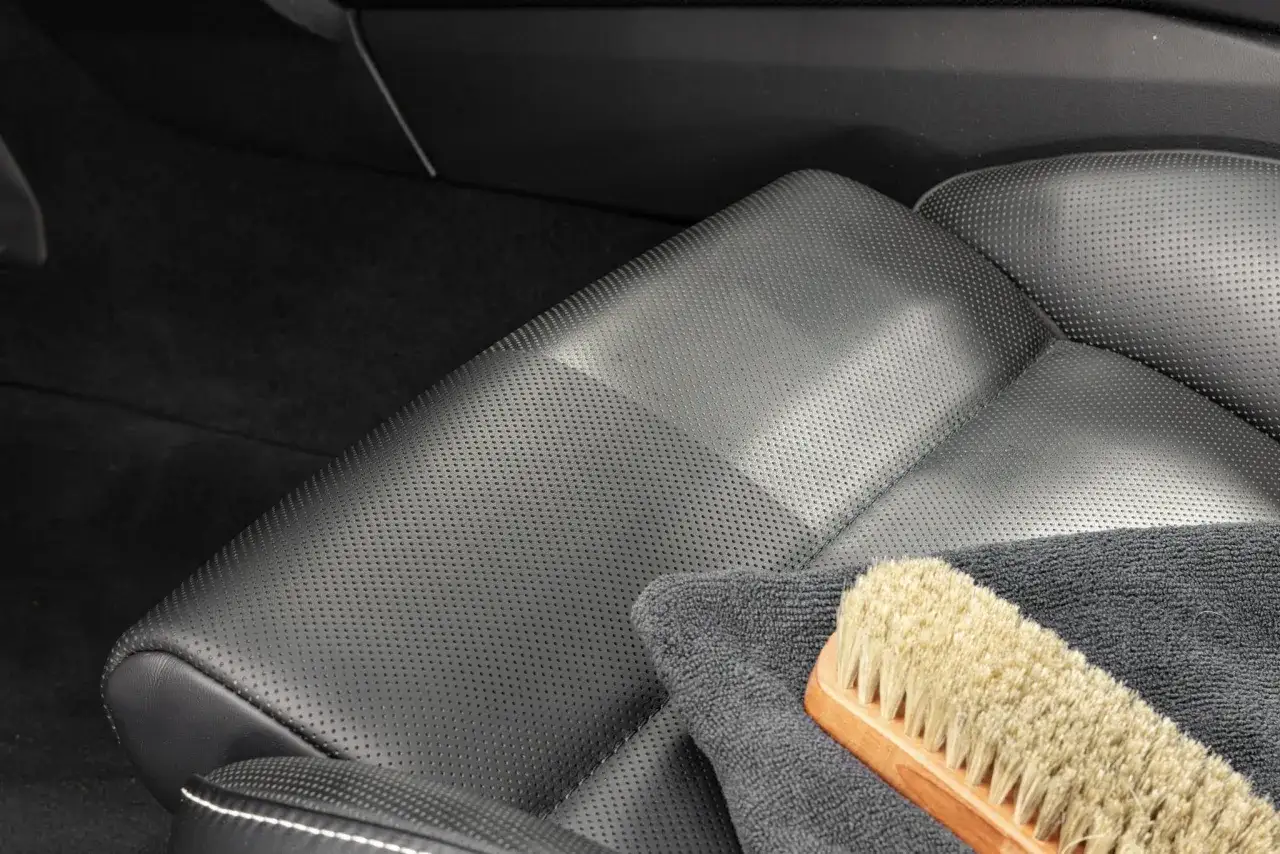 Ledersitz im Auto mit B&uuml;rste und Tuch. Perfekt f&uuml;r Leder reinigen Hausmittel.
