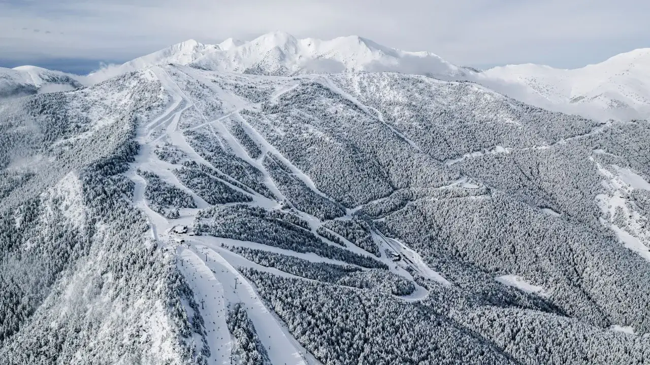 Impresionante vista a&eacute;rea de Grau Roig, con pistas de esqu&iacute; serpenteando entre bosques nevados y picos majestuosos.