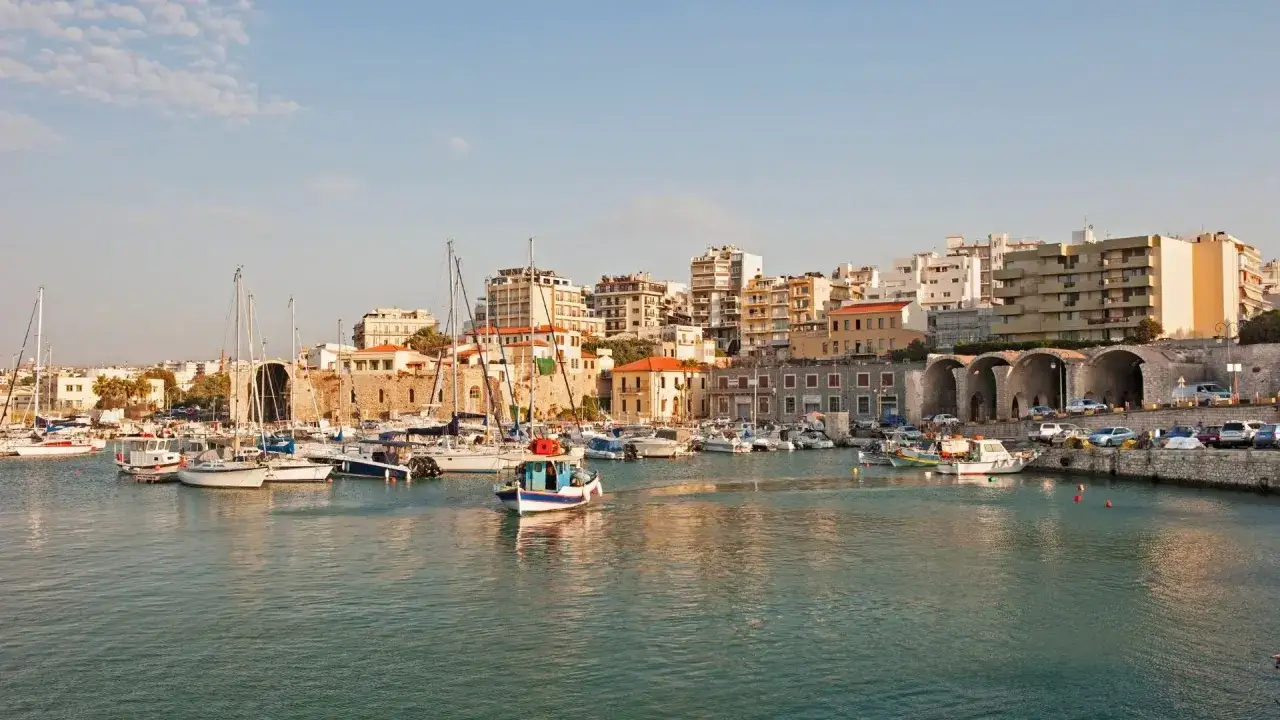 Port w Heraklionie, Kreta. Widać zacumowane łodzie i budynki.