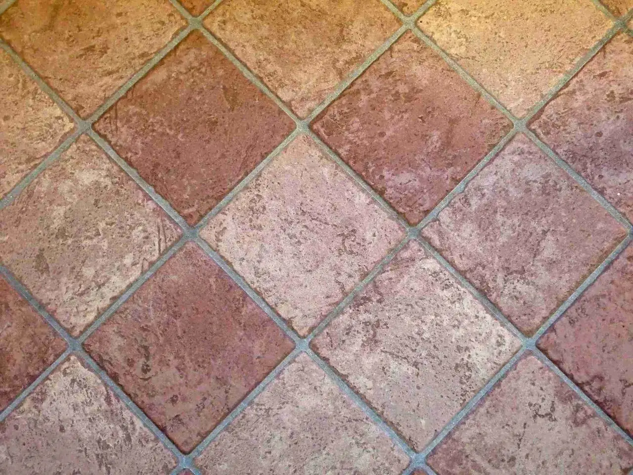 Carrelage mal pos&eacute;, les carreaux de terre cuite sont de travers, cr&eacute;ant un motif irr&eacute;gulier et peu esth&eacute;tique.