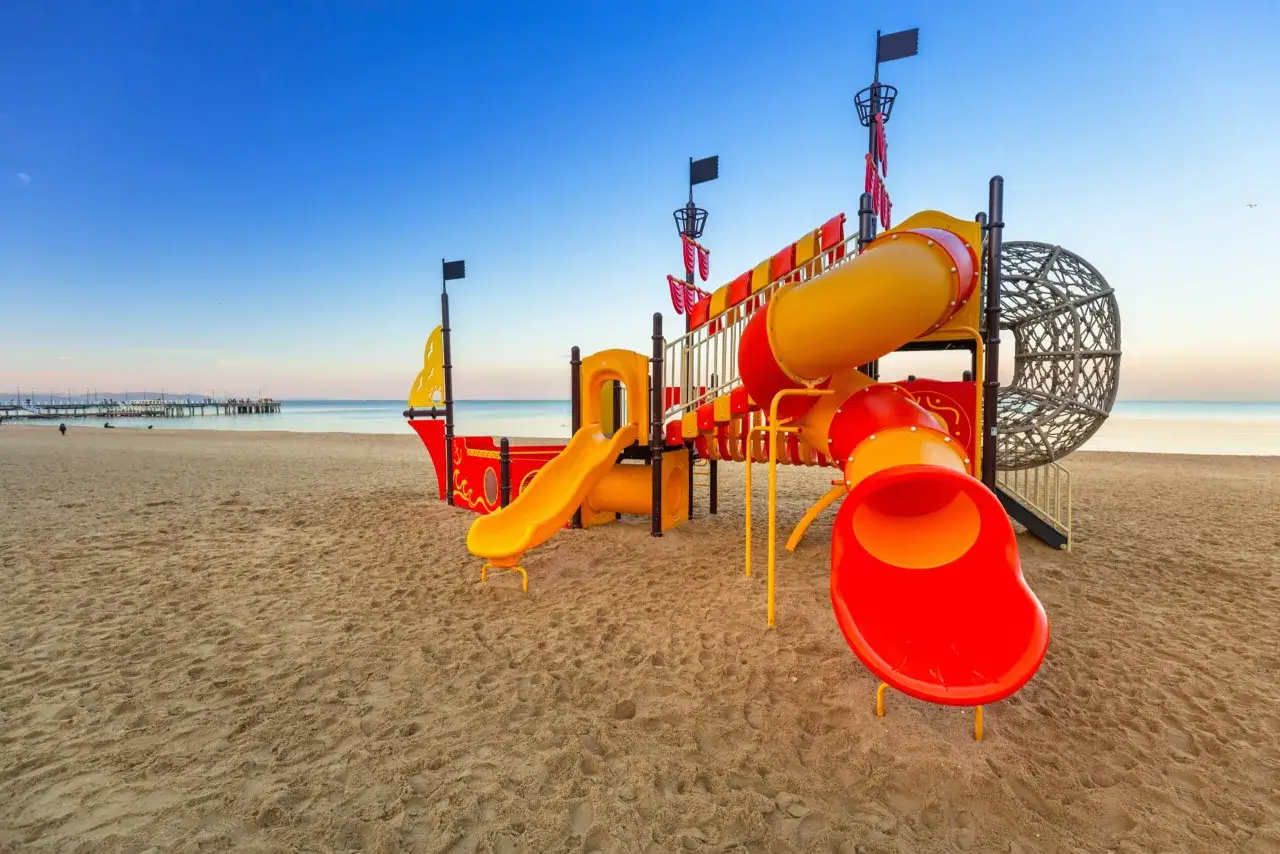 Kolorowy plac zabaw w kształcie statku pirackiego na piaszczystej plaży. Idealne miejsce na wakacje, gdansk dla dzieci.