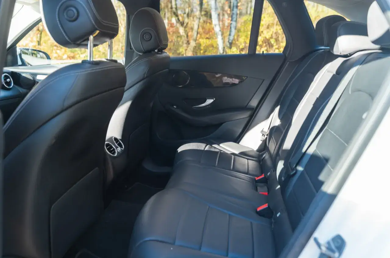 Wnętrze Mercedesa GLC 200 4Matic: czarne, skórzane fotele z białymi przeszyciami, widok z tyłu.