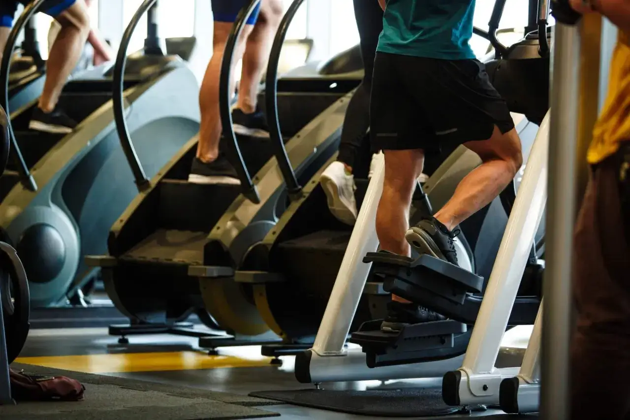 Beine trainieren auf Stairmaster-Geräten im Fitnessstudio.