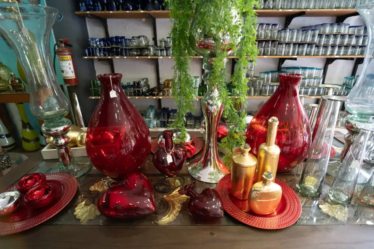 Jarrón rojo brillante, corazones de vidrio y botellas doradas, parte de la historia del vidrio.
