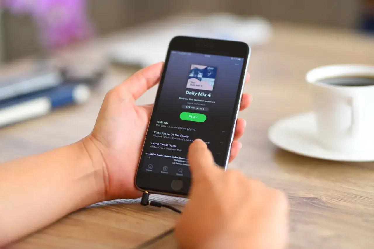 Hand h&auml;lt Smartphone mit Spotify-App. &Uuml;ber Spotify Connect kann Musik auf anderen Ger&auml;ten abgespielt werden.