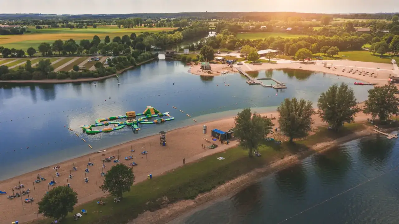 Sommerliche Ausflugsziele Niederrhein: Badesee mit Wasserrutsche, Strand und Liegest&uuml;hlen.