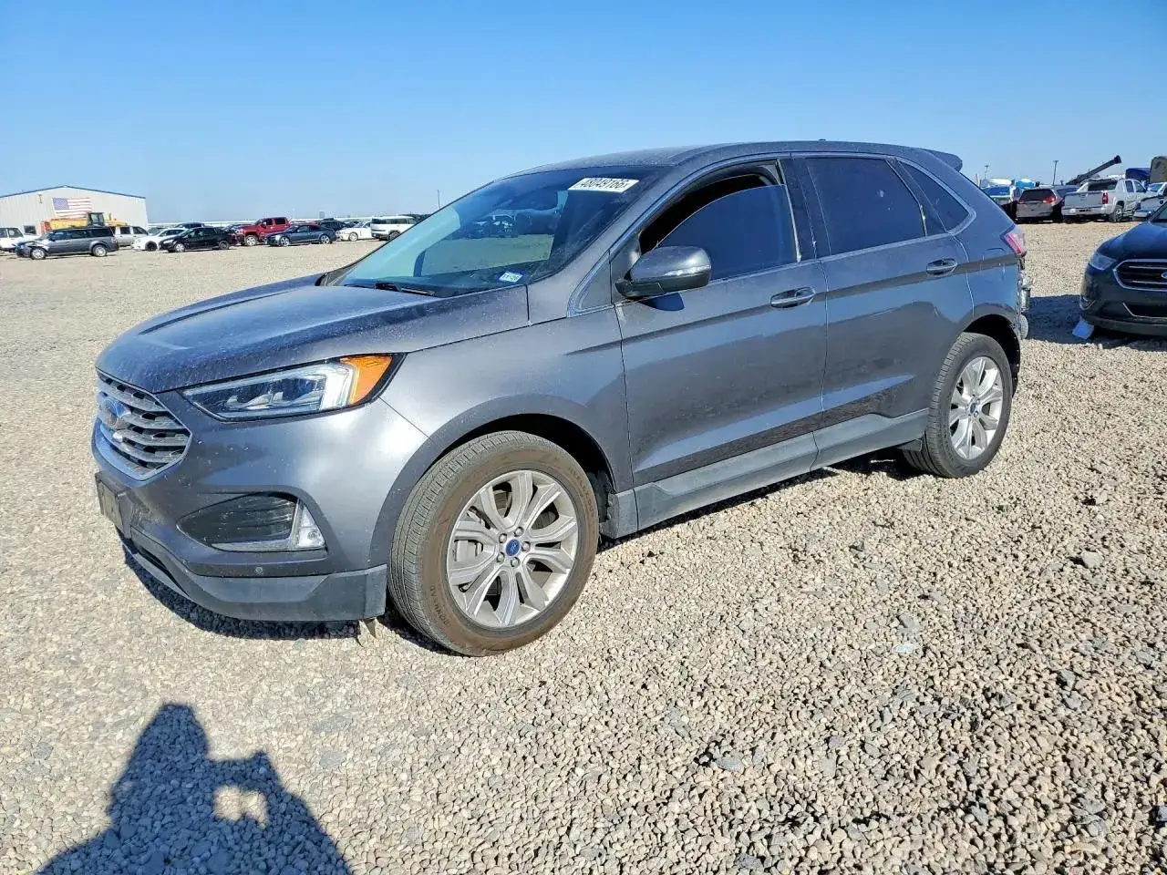 Szary Ford Edge 2.0 EcoBoost stoi na placu złomowiska.