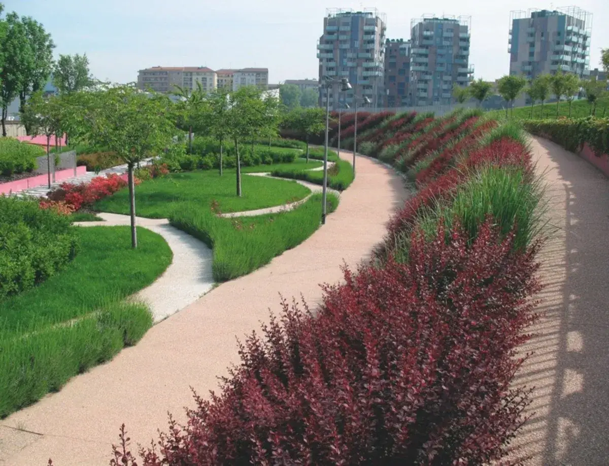Ein moderner Park mit geschwungenen Wegen, gr&uuml;nen Rasenfl&auml;chen und bunten Beeten, der das urbane Leben bereichert.