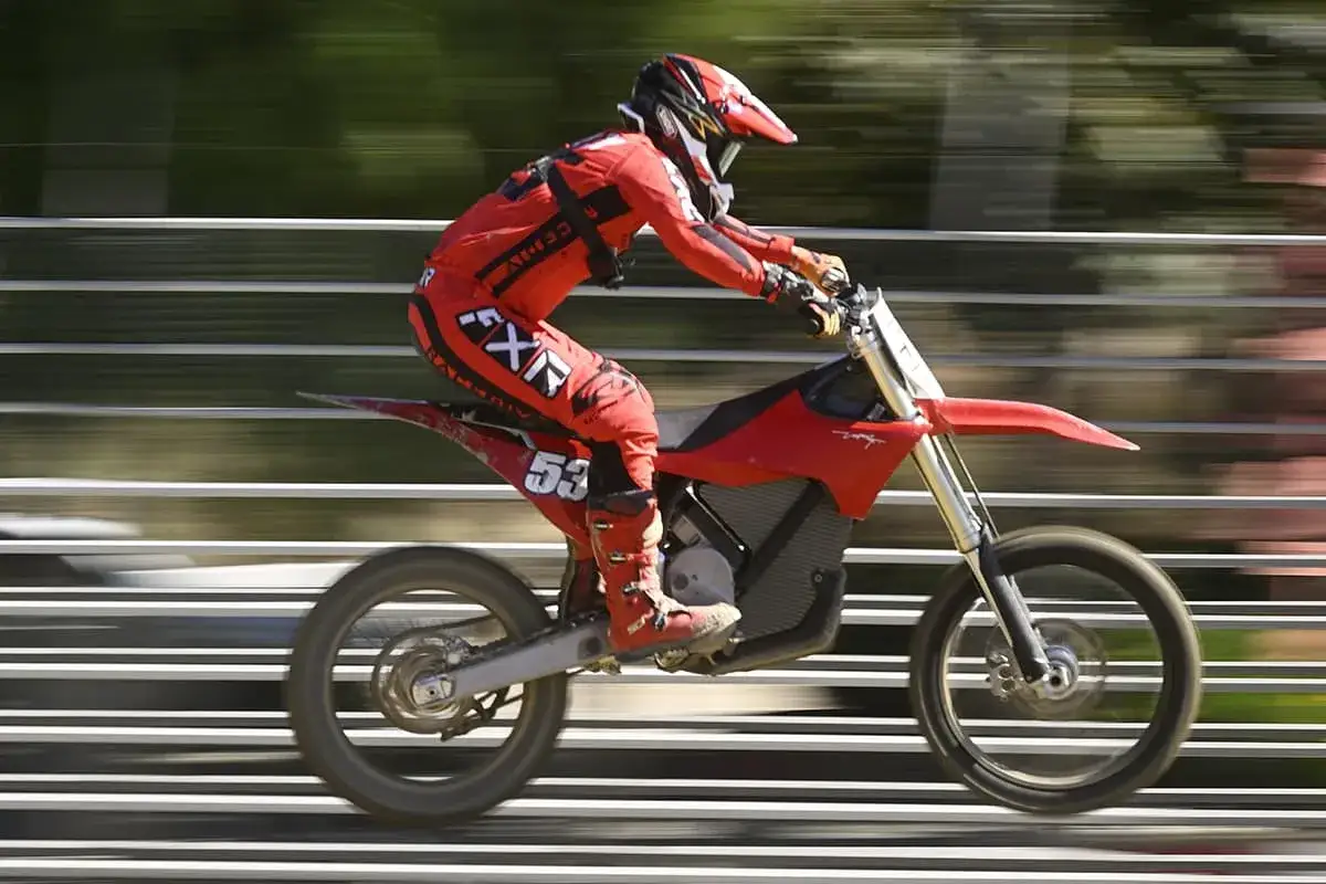 Ein Fahrer in roter Montur auf einem roten Stark Motorrad rast über eine Bahn.