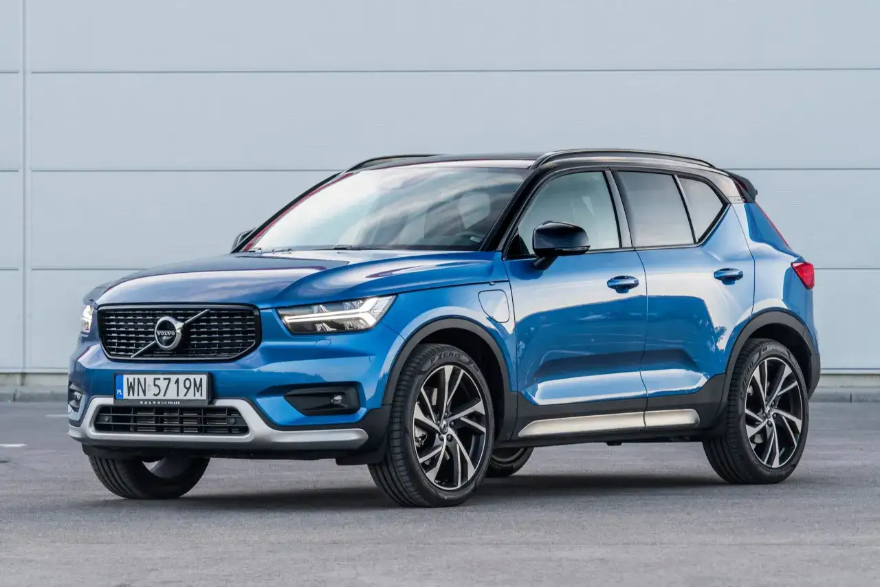 Niebieski Volvo XC40 prezentuje swoje kompaktowe wymiary, idealne do miasta. Elegancki design i sportowe felgi podkreślają jego charakter.
