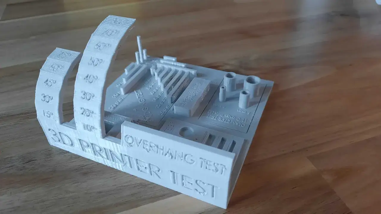 Biały model 3D do testu drukarki, z oznaczeniami kąt&oacute;w, mostk&oacute;w i średnic.