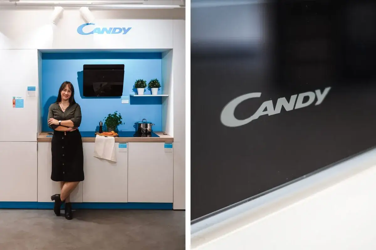 Kobieta w kuchni z logo Candy. To firma produkująca sprzęt AGD, znana z innowacyjnych rozwiązań.