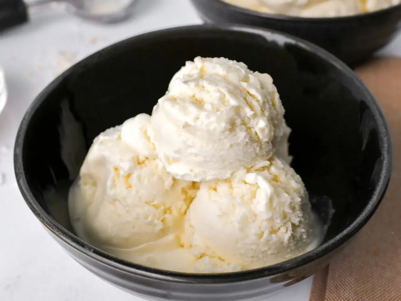 Delicioso helado de coco cremoso servido en un tazón negro.