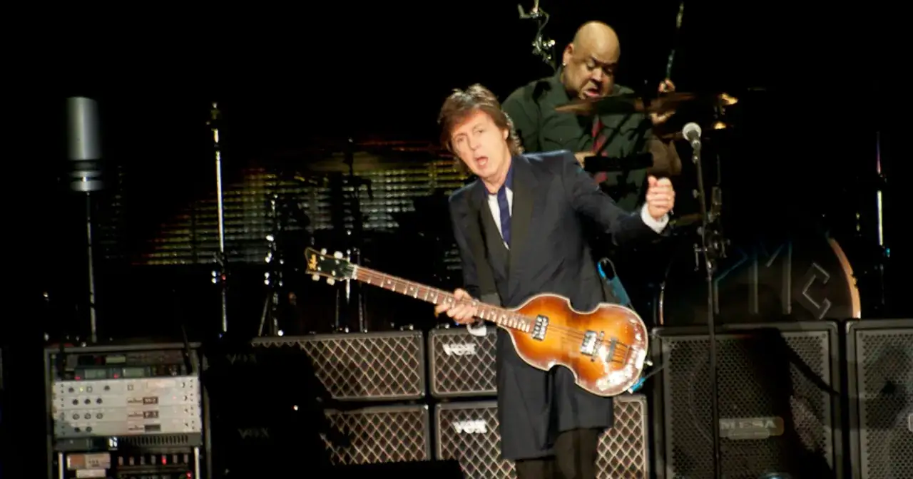 Paul McCartney na jednym ze swoich koncertów, grając na gitarze basowej. W tle perkusista.