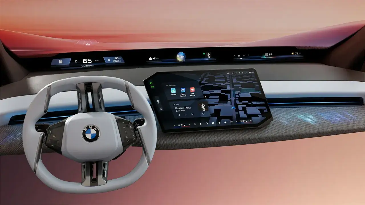 Interni futuristici del **BMW X5 2026**: volante, ampio display con navigazione e musica, e cruscotto digitale.