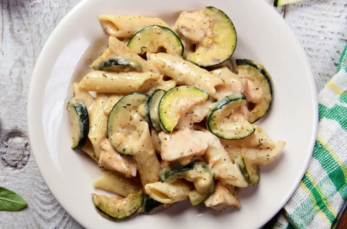 Penne z kurczakiem i cukinią w kremowym sosie, posypane ziołami. Pyszne danie, które zachwyci każdego.