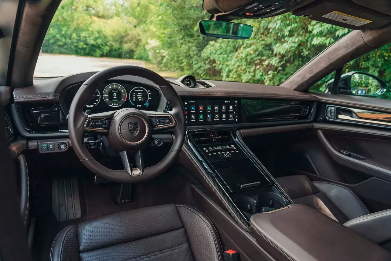 Wnętrze Porsche Panamera Turbo S z brązową skórzaną tapicerką i nowoczesnym panelem sterowania.