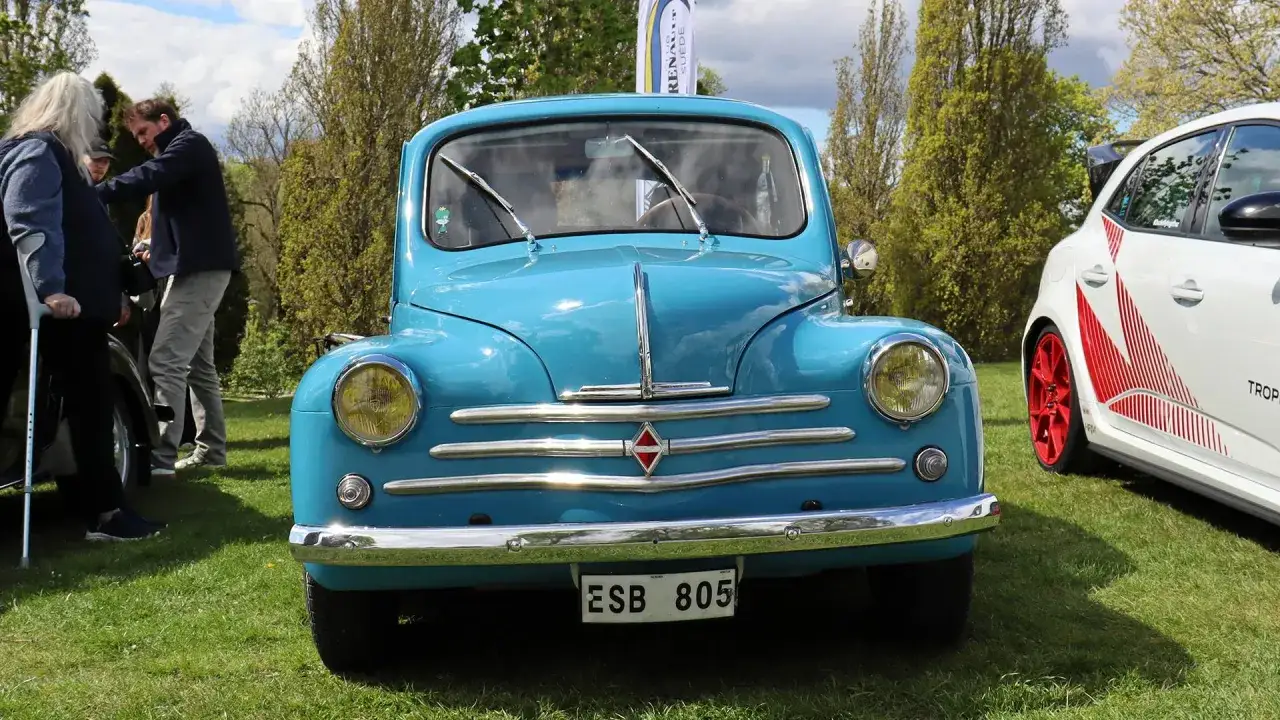 En bl&aring;, klassisk Renault 16 st&aring;r p&aring; en gr&auml;smatta, bredvid en modernare vit bil.