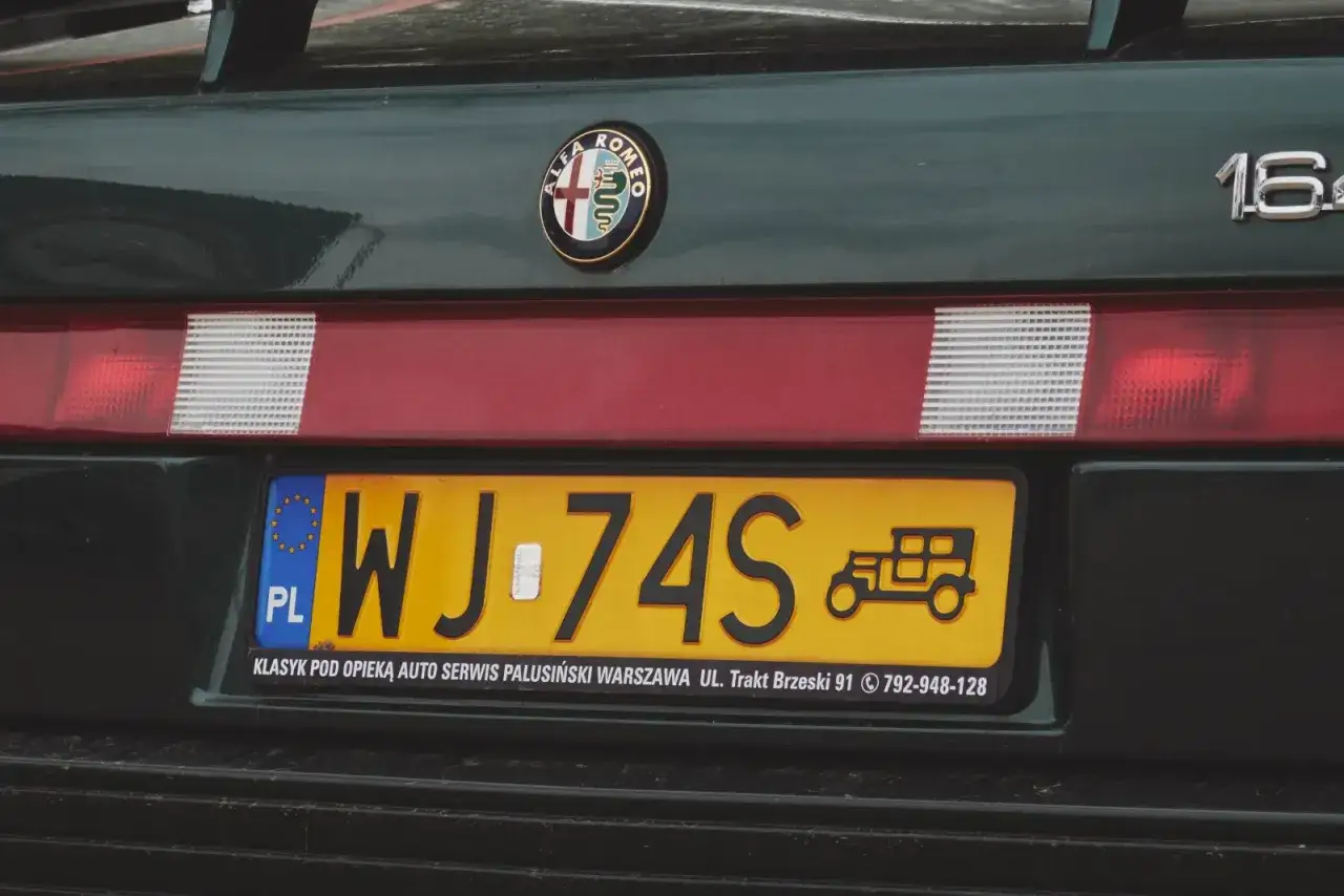 Zielony pojazd zabytkowy Alfa Romeo z tablicą rejestracyjną WJ-74S i symbolem starego auta.