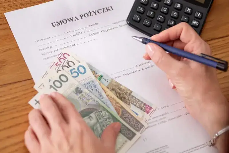 Umowa pożyczki prywatnej, długopis i kalkulator na stole