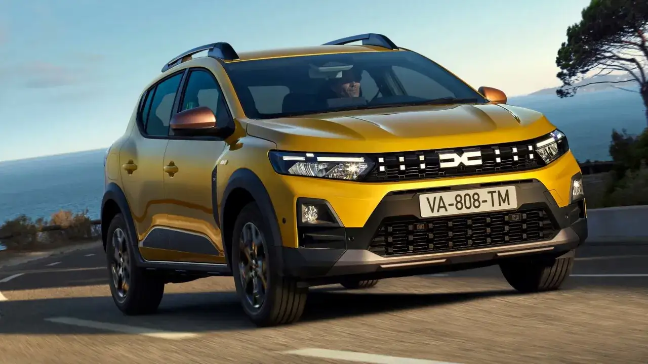 Żółty Dacia Jogger, jeden z nowych dacia modele, jedzie nad morzem.