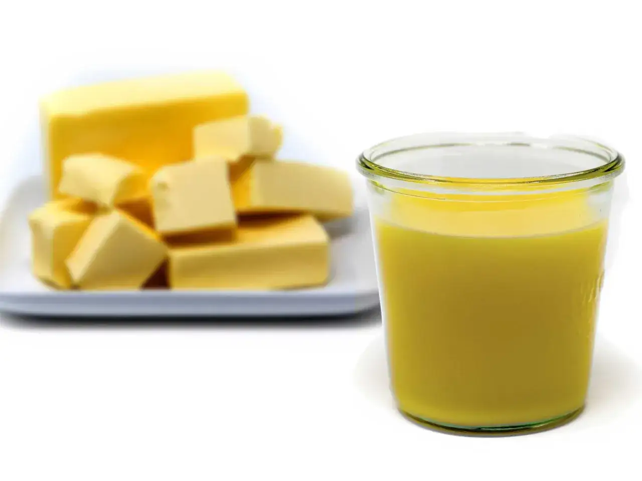 Ein Glas mit flüssigem Butterschmalz steht neben einem Block Butter, der in Stücke geschnitten ist.