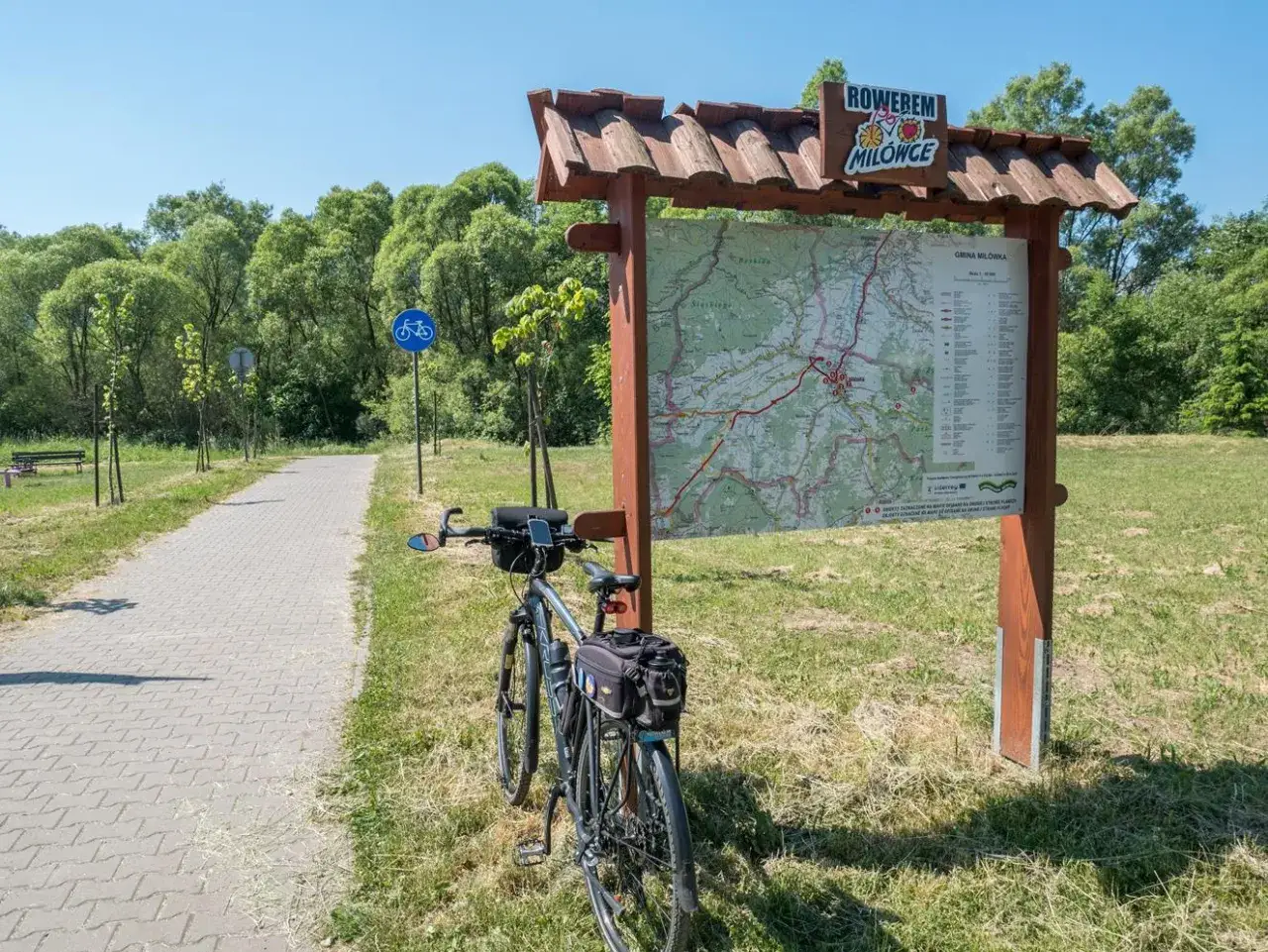 Rower czeka przy mapie szlaków rowerowych Gminy Milówka. Czas na wycieczkę velo soła!