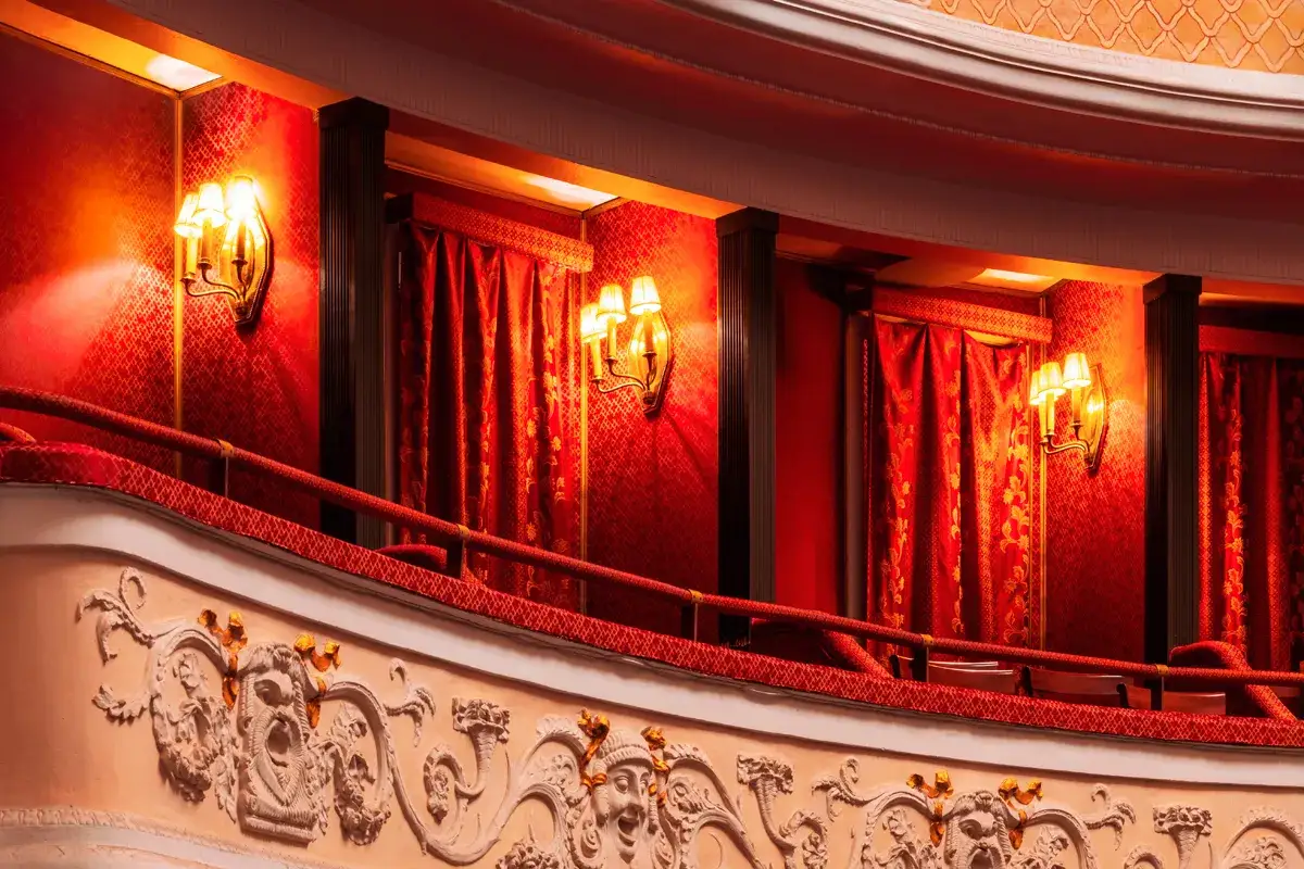Eleganckie loże i czerwone zasłony zapraszają na niezapomniane przedstawienia teatralne w Warszawie.