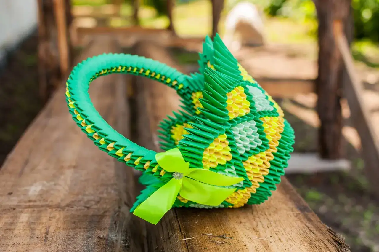 Grüne und gelbe 3D-Origami-Körbchen mit Schleife, perfekt für eine Bastelanleitung.
